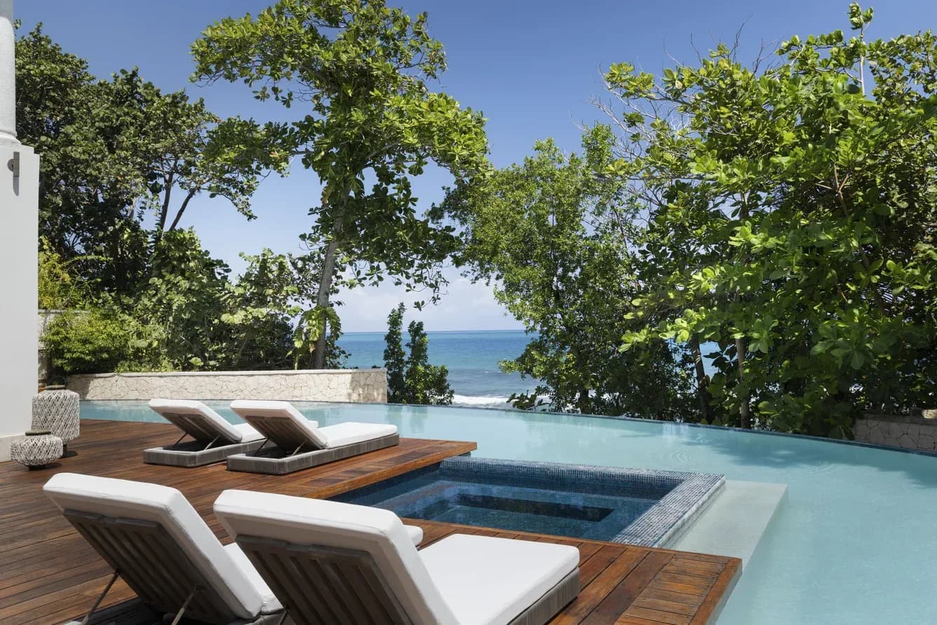 Infinity-Pool mit Liegen über dem Meer