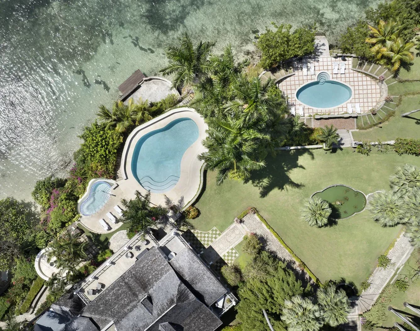 Blick von oben auf die Pools und den Garten